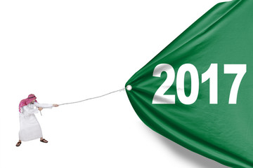 Arabian male pulling a big flag