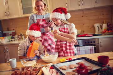 Family of children and mother baking cookies at home .