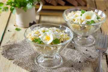 Salad with pickled herring, cheese and egg. Appetizer on a festi