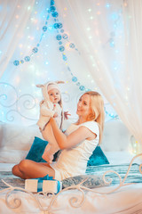 Obraz na płótnie Canvas Merry Christmas! beautiful young mother with child have fun in bedroom decorated on christmas. Christmas, new year, family, holiday concept.
