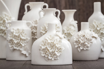 Different Decorative White Vases on Brown Background