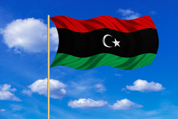 Flag of Libya waving on blue sky background