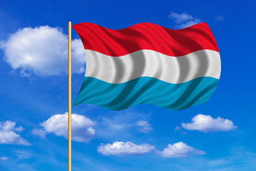 Flag of Luxembourg waving on blue sky background