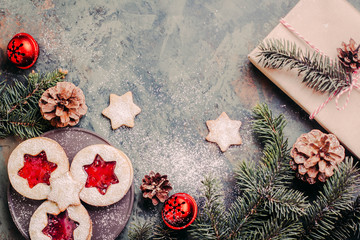 Christmas background - fir tree, gift box and holiday cookies with decoration on dark table