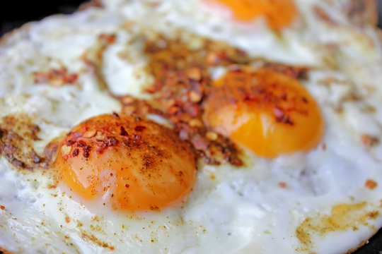 Fried eggs in with red hot chilly peppers