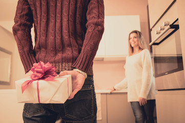 Man is hiding behind his back a gift for his girlfriend