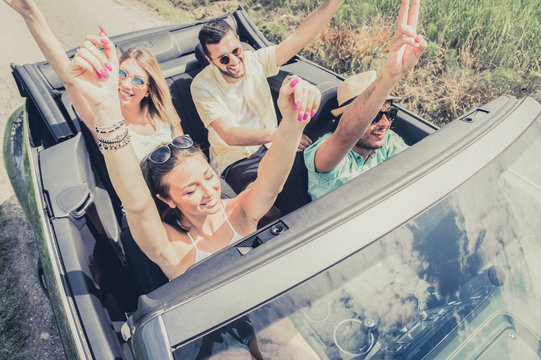 Group of young people dancing and having fun at car trip.