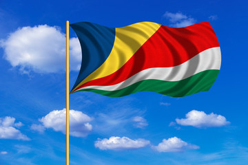 Flag of Seychelles waving on blue sky background