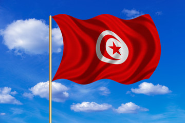 Flag of Tunisia waving on blue sky background