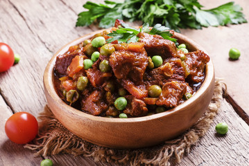 Beef stew, meat ragout with carrots, onions and green peas, vint