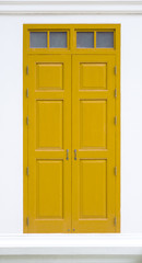 traditional yellow door wooden of an old on white wall,in Thailand