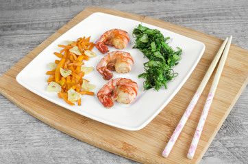 Shrimp on plate and wooden background. Selective focus.