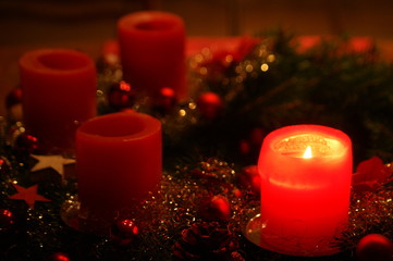 Adventskranz rot geschmückt mit vier Kerzen