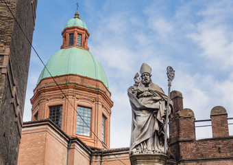 Fototapeta na wymiar Statue of Bishop St. Petronius, Garisenda tower. Bologna, Italy