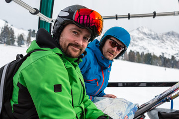 Happy skiers sitting in gondola lift