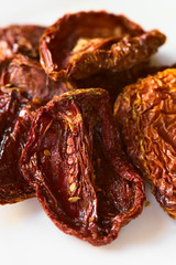 Sun-dried tomato halves on white plate, photographed with natural light (Selective Focus, Focus in the middle of the image)