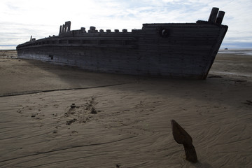 Old wooden ship stranded on a sandy beach. Laptev sea. Yakutia. Russia.