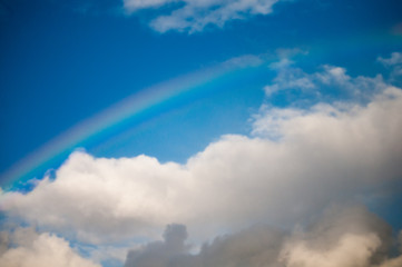 Naklejka na ściany i meble Rainbow in blue cloudy sky
