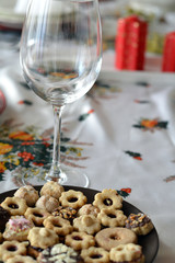 Christmas cookies with chocolate,nuts and coconut decorated on a plate on a table with lighted candles