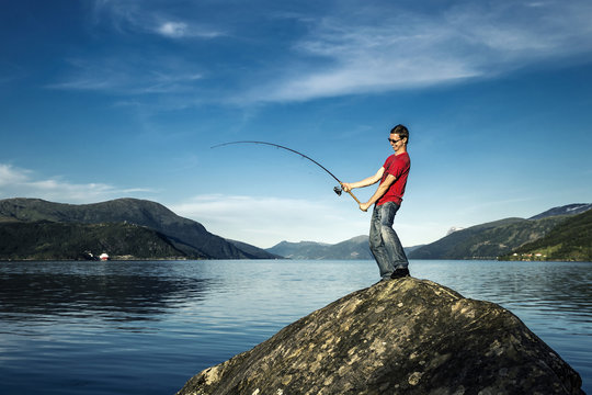 Young man is fishing in Norway