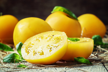 Cut large yellow tomatoes and green leaves of basil, vintage woo