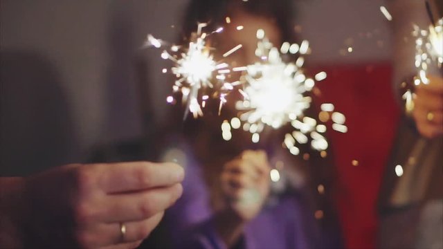 Close up family hands with sparklers lights in christmas eve HD