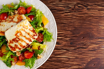 Grilled Halloumi Cheese salad witch orange, tomatoes and lettuce. healthy food