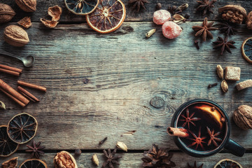 Mulled wine in rustic mug with spices and ingredients. Top view.