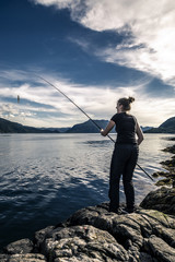 Young woman is fishing in Norway