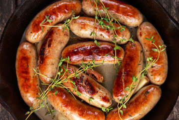 Home-made Pork Sausages in rustic pan with thyme