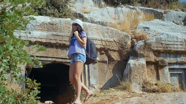 Young woman tourist walking near ruins