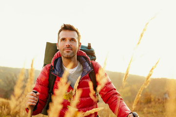 Young man hiking with backpack during fall, autumn