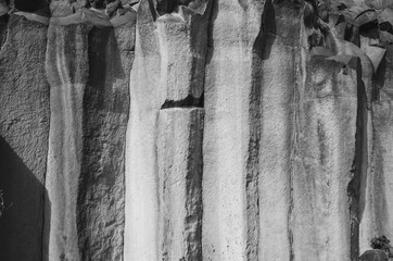 Natural gray basalt rock columns interesting closeup texture. Empty background space for text,...