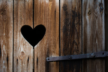 Heart cut in old vintage rustic wooden timbers as a background
