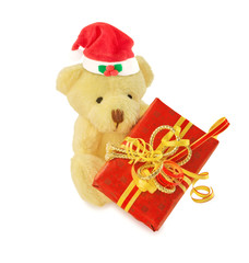 Teddy bear with Santa hat and gift on white.