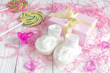 baby's bootees and gift box on wooden background