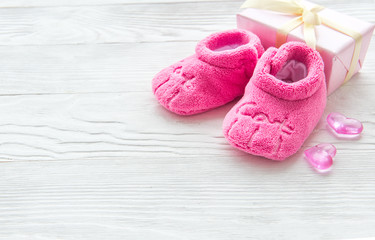 Obraz na płótnie Canvas pink baby's bootees on wooden background