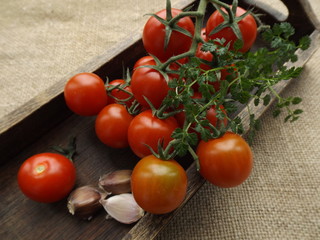 cherry tomatoes and garlic in a wooden box