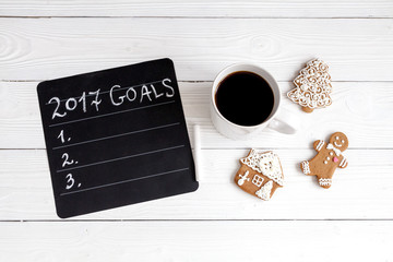 notebook and goals for new year wooden background top view