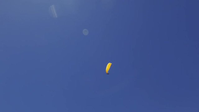 paragliding over the Alps mountains against blue sunny sky
