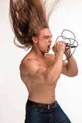 singer bodybuilder shirtless with long hair with a microphone on a white background