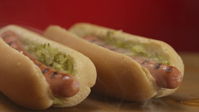 Appetizing steaming hot dog on red background. Shot on RED EPIC DRAGON Cinema Camera.