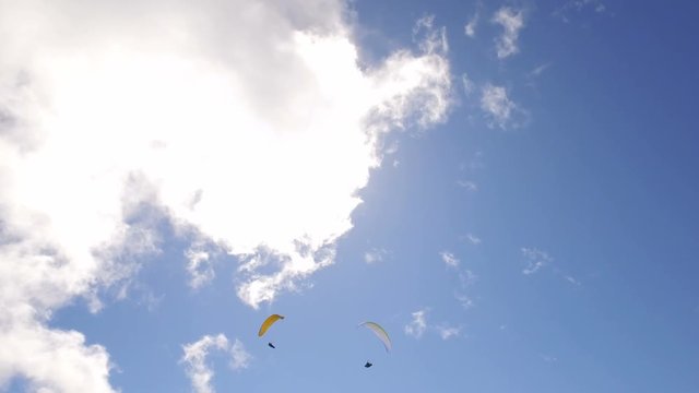 paragliding over the Alps mountains against blue sunny sky