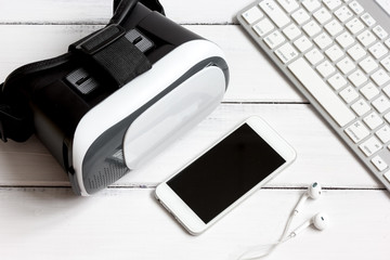 virtual reality glasses with smartphone, keyboard on wooden background