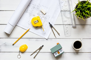 engineering tools on wooden table with drawings apartments top view