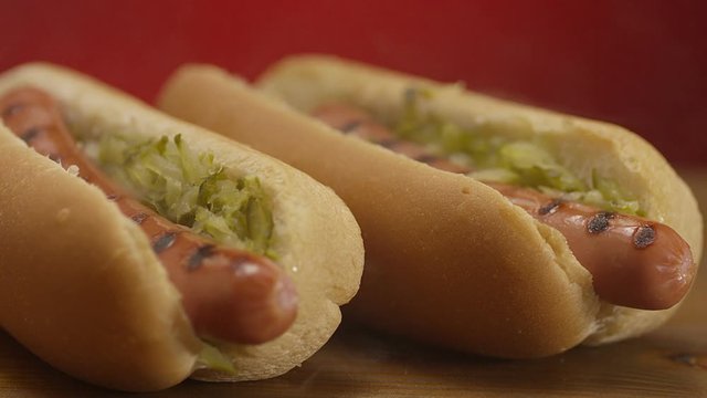Appetizing steaming hot dog on red background. Shot on RED EPIC DRAGON Cinema Camera.