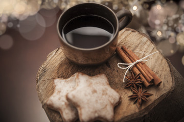 Christmas gingerbread cookies  coffe on a wooden stump with cinnamon, anise, christmas decoration and holiday lights.