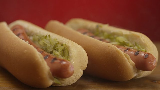 Appetizing steaming hot dog on red background. Shot on RED EPIC DRAGON Cinema Camera.