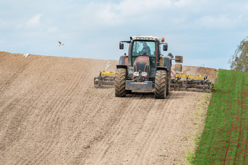 Obraz premium Tractor harrowing the field