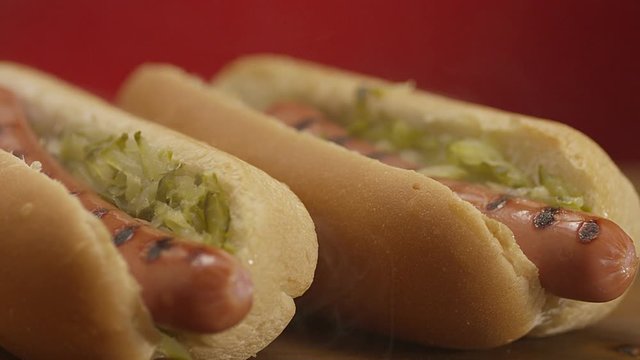 Appetizing steaming hot dog on red background. Shot on RED EPIC DRAGON Cinema Camera.